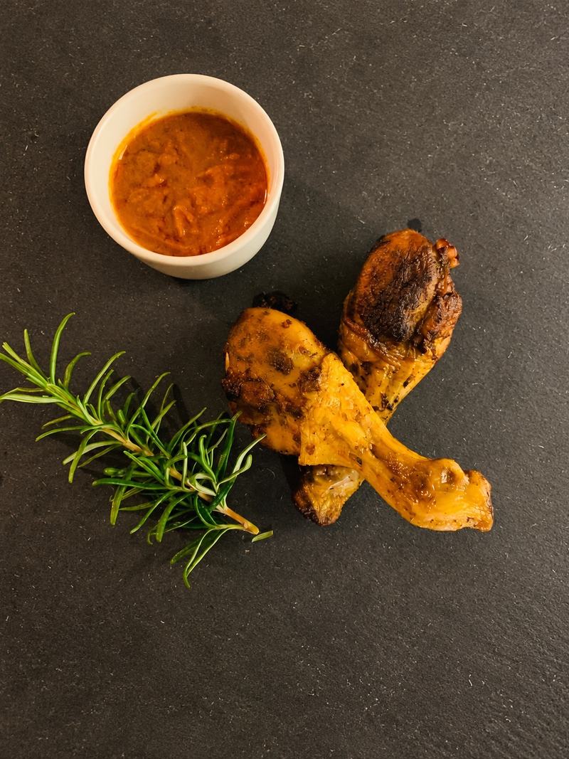 Pilons de poulet grillés, sauce arachide et romarin sur une ardoise